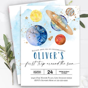 May include: A blue and white watercolor invitation with gold glitter accents. The invitation features planets and stars and the text "Please join us in celebrating Oliver's first trip around the sun. Saturday February 24. From 10:00am-12:00pm. 32421 Oak Manor Place, Los Angeles 93932. RSVP: Oliver's Mom at 251-555-9392."