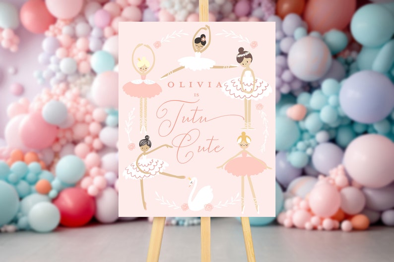 May include: A pink sign with a gold inscription that reads "Olivia is Tutu Cute". The sign is decorated with five ballerina illustrations wearing pink and white tutus. The sign is on a wooden easel.