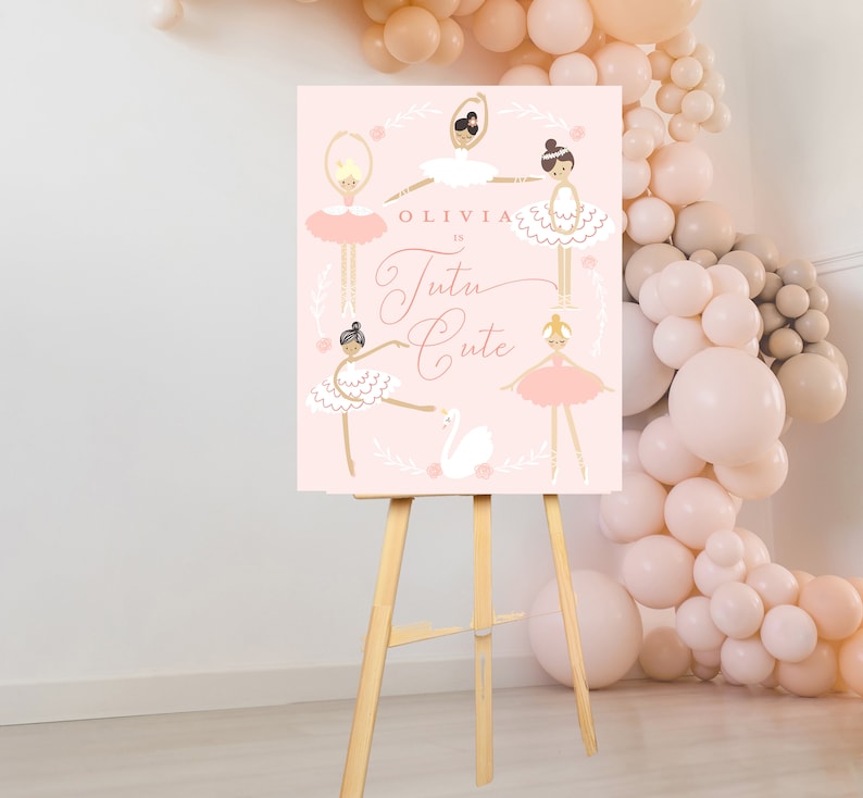 May include: A pink sign with a white border and a white swan illustration. The sign says "Olivia is Tutu Cute" and features five ballerina illustrations. The sign is on a wooden easel.