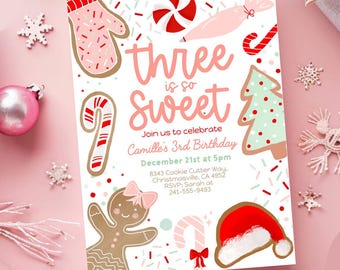 以下が含まれることがあります： ピンクと白のデザインの誕生日招待状。「Three is so Sweet」というテキストと、ジンジャーブレッドマン、キャンディケーン、サンタ帽子のイラストが描かれています。招待状はカミーユの3歳の誕生日用です。