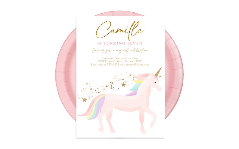 May include: Pink invitation with gold glitter text that reads "Camille is turning seven. Join us for a magical celebration. Saturday, March 17th at 3pm. 9394 Unicorn Way, Univille 9192. RSVP at 555-9931 or unicorn@email.com". The invitation features a pink unicorn with a rainbow mane and tail against a white background with gold glitter stars.