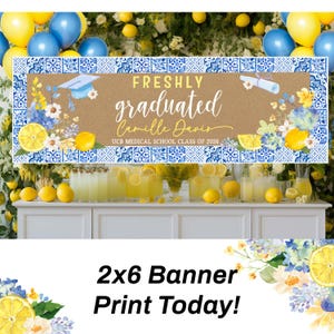 May include: A banner with a brown background and blue and white patterned border reads "FRESHLY graduated Camille Davis UCB MEDICAL SCHOOL CLASS OF 2026." The banner is decorated with lemons, flowers, and a graduation cap. The banner is 2x6 feet.