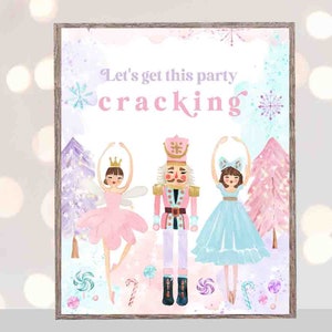 May include: A pink and blue printable sign with the text "Let's get this party cracking" and illustrations of a Nutcracker, a ballerina in a pink tutu, and a ballerina in a blue tutu. The sign is decorated with snowflakes and candy canes.