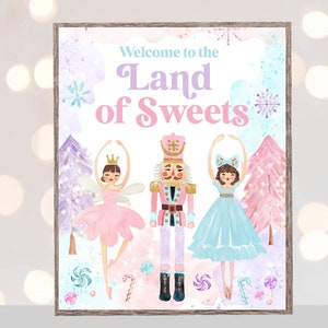 Puede incluir: Un cartel imprimible con un fondo de acuarela que presenta un Cascanueces, una bailarina con un tutú rosa y una bailarina con un tutú azul. El cartel dice "Bienvenido a la Tierra de los Dulces".
