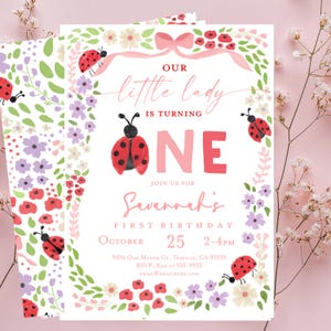 Può includere: Un invito di compleanno con un tema floreale e coccinella. L'invito recita "Our little lady is turning ONE" con il nome "Savannah's" e la data "25 ottobre". Il design include fiori rosa, rossi e viola.