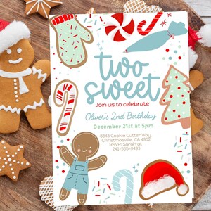 May include: A festive birthday invitation with the text "two sweet" in light blue, surrounded by gingerbread cookies and Christmas-themed illustrations. The invitation includes details for Oliver's 2nd birthday on December 21st.