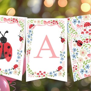 May include: A decorative banner featuring ladybugs and floral patterns. The banner includes a large red ladybug with black spots, the letter "A", and a floral design with red, blue, and white flowers. Pink bows and ladybugs adorn the edges.