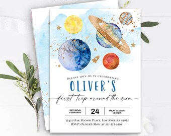 May include: A blue and white watercolor invitation with gold glitter accents. The invitation features planets and stars and the text "Please join us in celebrating Oliver's first trip around the sun. Saturday February 24. From 10:00am-12:00pm. 32421 Oak Manor Place, Los Angeles 93932. RSVP: Oliver's Mom at 251-555-9392."