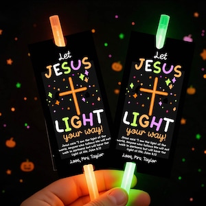 Può includere: Due segnalibri rettangolari neri con una grafica a croce arancione, accenti di stelle colorate e il testo Let JESUS LIGHT your way! insieme al versetto biblico Giovanni 8:12 e Love, Mrs. Taylor. Ogni segnalibro ha un bastoncino luminoso arancione o verde.