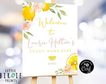 May include: Welcome to Laurie Hilton's event sign with a lemon and floral design. The sign is white with pink and yellow text. The date 8/10/21 is printed on the sign.