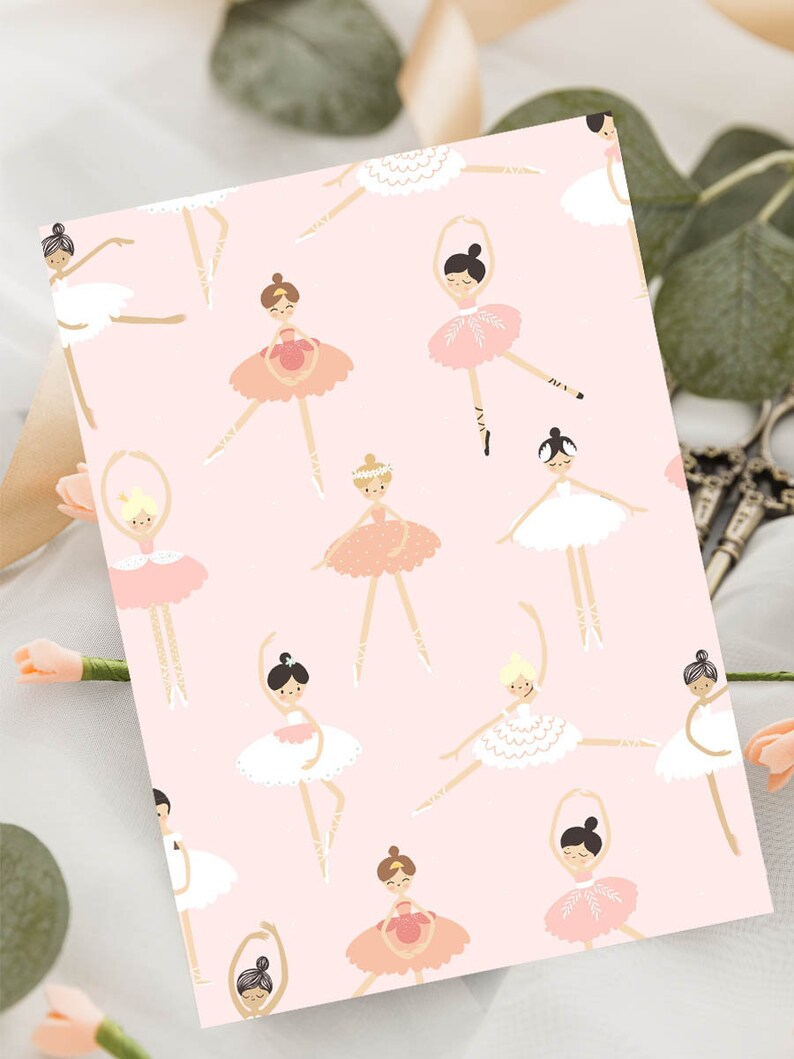 May include: Pink wrapping paper with a repeating pattern of ballerinas in various poses wearing pink, white and gold tutus. The ballerinas have brown, black and blonde hair.