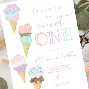 May include: A pink and purple birthday invitation with a sweet one theme. The invitation features three ice cream cones with sprinkles and a pink and purple background. The text on the invitation reads "Olivia is a sweet one" and includes details for the birthday party.