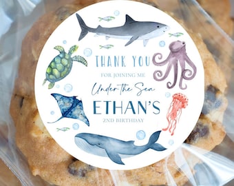 Op de afbeelding: Ronde sticker met een witte achtergrond en blauwe en groene aquarel illustraties van zeedieren. De tekst "Thank You for joining me Under the Sea Ethan's 2nd Birthday" is op de sticker gedrukt.