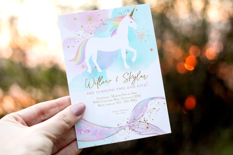 Op de afbeelding: Een wit eenhoorn met een regenboogmanen en staart staat op een blauwe en roze aquarel achtergrond met gouden glitter. De tekst "Willow & Skylar worden twee en vijf!" is onder het eenhoorn gedrukt. De uitnodiging bevat details voor een verjaardagsfeest, inclusief datum, tijd, adres en RSVP-informatie.