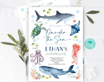 May include: A blue and white invitation for a first birthday party with the theme "One-der the Sea". The invitation features a shark, a turtle, an octopus, a whale, a jellyfish, and a starfish. The text on the invitation reads "It's a party One-der the Sea Join us to celebrate at Ethan's first birthday party Saturday, July 18th at 5pm 3939 West Palm Way Ocean City, Florida 33992 Bring a swimsuit RSVP Carson at 555-93939 by June 28th"