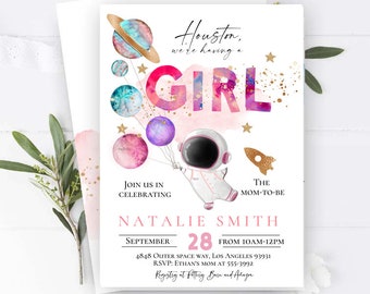 May include: A pink and blue baby shower invitation with a watercolor design of planets and stars. The text reads "Houston, we're having a girl" and includes the date, time, and location of the event.