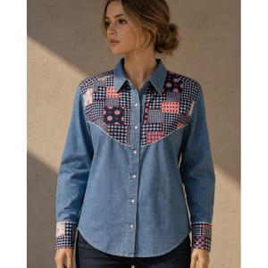 May include: A denim shirt with a patchwork design on the yoke and cuffs. The shirt has a classic collar and button-up front. The patchwork incorporates pink, navy, and white patterns. Long-sleeved.