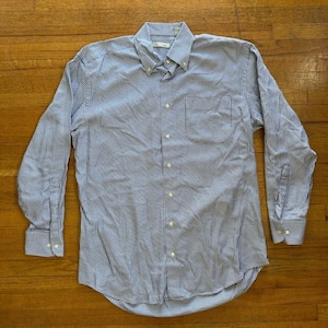 以下が含まれることがあります： 青と白のチェック柄のボタンダウンシャツ、長袖。 シャツはボタンダウンカラー、胸ポケット、白いボタンが付いています。 生地は小さな、繰り返しのチェック柄です。