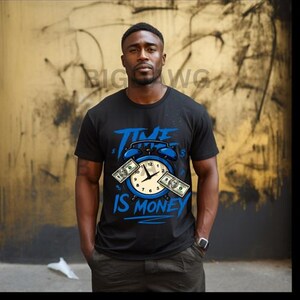 Può includere: T-shirt nera con grafica blu di un orologio e banconote. Il testo "TIME IS MONEY" è in blu. La persona indossa un orologio e pantaloni color cachi.