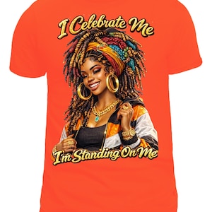 Può includere: T-shirt arancione con un'illustrazione di una donna con dreadlocks colorati, gioielli d'oro e giacca. Il testo "I Celebrate Me" e "I'm Standing On Me" è in lettere dorate.