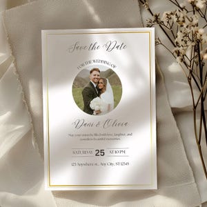 Könnte beinhalten: Eine Hochzeitseinladung mit goldenem Rand und dem Text "Save the Date". Sie zeigt ein Foto eines Paares und die Namen "Dani & Olivia". Die Einladung enthält Datum, Uhrzeit und Adresse der Hochzeit.