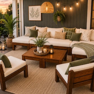 May include: Outdoor living space featuring a sectional sofa with white cushions and olive green pillows. Two wooden armchairs with white cushions and green pillows are in front of the sofa. A wooden coffee table and a woven light fixture complete the scene.