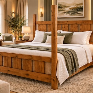 May include: A four-poster bed frame constructed from medium-toned wood with a vertical plank headboard and footboard. The bed is dressed in white bedding, including a white quilt and a textured olive green throw blanket, with two white pillows.