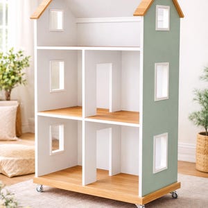 Peut inclure: Une maison de poupée en bois avec un intérieur blanc et un extérieur vert sauge. La maison de poupée a plusieurs pièces, des fenêtres et un toit en bois. Elle repose sur des roues pour faciliter le déplacement. La maison de poupée est conçue pour le jeu des enfants.