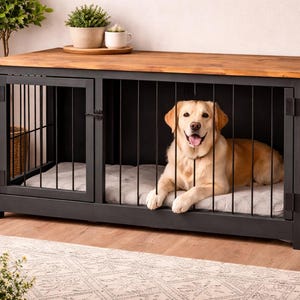 Puede incluir: Una jaula para perros con marco negro y tapa de madera. Un golden retriever está dentro de la jaula, acostado sobre un cojín gris. La jaula tiene una puerta y barras verticales. Plantas y una cesta en el fondo.