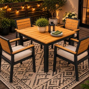May include: Outdoor dining set featuring a square wooden table with a black frame, surrounded by four matching chairs. The chairs have wooden backs and armrests, with beige cushions. The set is placed on a patterned rug, creating a cozy patio setting.