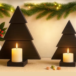 May include: Two dark brown wooden Christmas tree candle holders with lit white candles. The trees have a layered design and sit on square bases. A garland of greenery and red berries decorates the background.