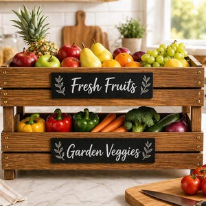 May include: A two-tiered wooden crate filled with fresh fruits and garden vegetables. The top level displays a pineapple, apples, pears, and grapes. The bottom level holds bell peppers, carrots, broccoli, and other produce. Black signs read "Fresh Fruits" and "Garden Veggies".