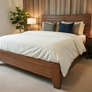 以下が含まれることがあります： 木製のベッドフレーム、白い掛け布団と枕を備えたモダンな寝室。 ヘッドボードは水平スラットのデザインです。 ベッドの両側にランプ付きの2つのベッドサイドテーブルがあります。 鉢植えの植物が緑を加えます。