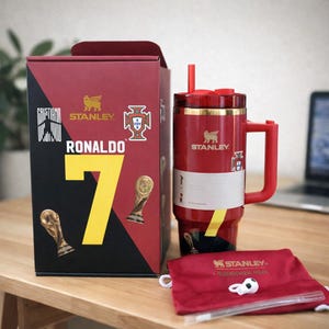 Pu&ograve; includere: Un bicchiere Stanley Quencher H2.0 rosso con bordo, manico e cannuccia dorati, caratterizzato da una grafica Ronaldo 7. &Egrave; esposto accanto alla sua scatola rossa abbinata con dettagli dorati, una sacca rossa con coulisse e un piccolo ciondolo a pallone.