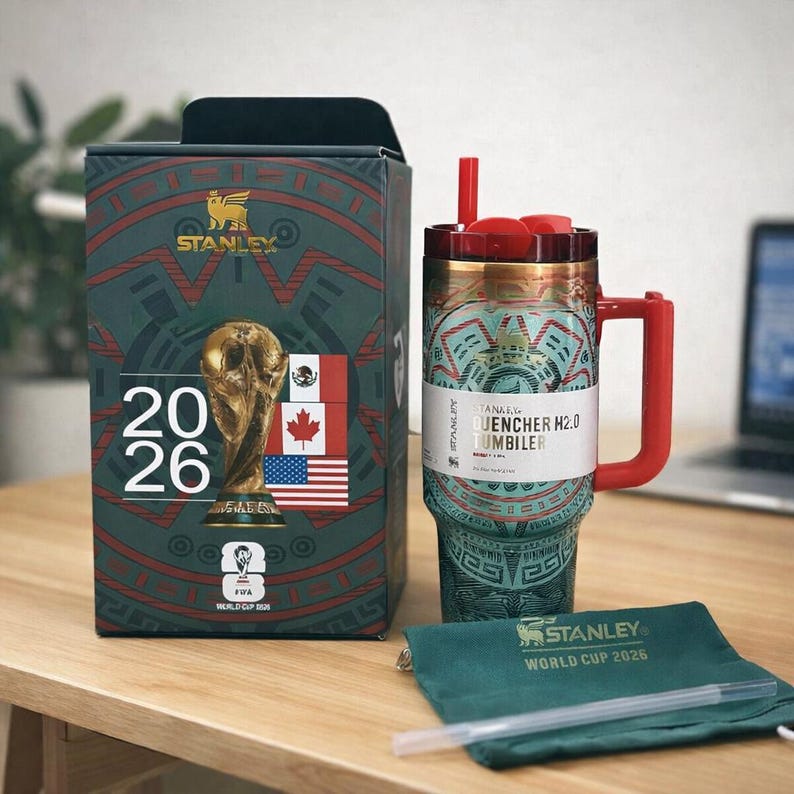 Pu&ograve; includere: Un bicchiere Stanley Quencher H2.0 con un motivo decorativo color verde acqua e rosso, manico rosso e cannuccia rossa. &Egrave; accompagnato da una scatola verde scuro coordinata con il logo della Coppa del Mondo FIFA 2026, il trofeo e bandiere.