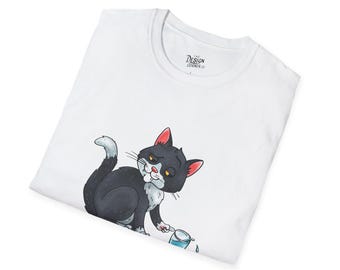 May include: White t-shirt featuring a cartoon cat with black fur, red ears, and a grumpy expression. The cat is holding a small glass with water spilling out. The shirt has a crew neck and the text "The Design Corner" on the tag.