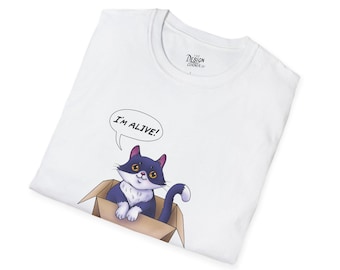 May include: White t-shirt featuring a cartoon cat in a cardboard box. The cat is black and white with yellow eyes and a blue tail. A speech bubble above the cat says "I'M ALIVE!" The shirt has a crew neck and a tag that says "The Design Corner".