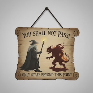 May include: Wooden sign with the text "YOU SHALL NOT PASS!" and "ONLY STAFF BEYOND THIS POINT". The sign features a wizard with a staff facing a fiery demon. The sign is brown with a black hanging cord.