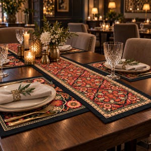 May include: A dark navy blue table runner and matching placemats featuring a vibrant, symmetrical floral pattern in shades of red, orange, green, and cream. The set is arranged on a wooden table with white plates, crystal glasses, and napkins.
