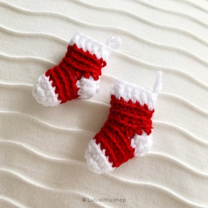 May include: Two small red and white crocheted Christmas stockings with a white fluffy trim.