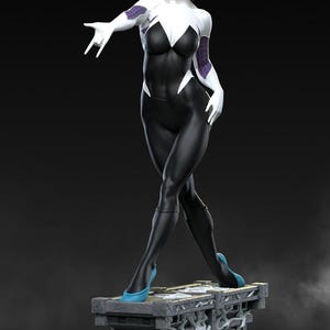 May include: A statue of a female superhero in a black and white bodysuit with a spider-web design. The figure has blonde hair and is wearing blue heels. The statue is standing on a stone platform with a brick base.
