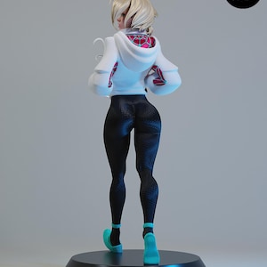 Op de afbeelding: Een beeldje van een personage in een witte hoodie met een rood en roze spinnenwebontwerp, zwarte legging en turquoise schoenen. Het beeldje staat op een zwarte cirkelvormige basis. Het beeldje staat met de rug naar de kijker toe.