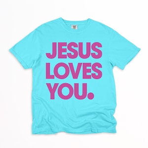 K&ouml;nnte beinhalten: Ein t&uuml;rkisfarbenes T-Shirt mit dem Aufdruck "JESUS LOVES YOU." in kr&auml;ftigen, pinkfarbenen Buchstaben. Der Text ist mittig auf der Vorderseite platziert. Das Shirt hat einen Rundhalsausschnitt und kurze &Auml;rmel.