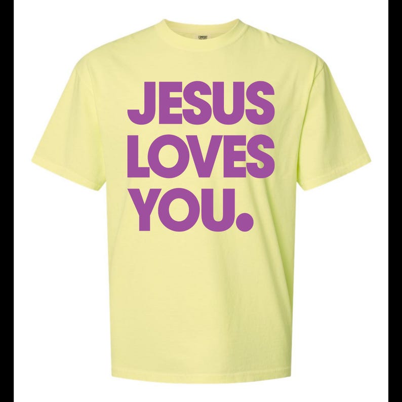 K&ouml;nnte beinhalten: Hellgelbes T-Shirt mit dem Text "JESUS LOVES YOU." in gro&szlig;en, lila Buchstaben. Das kurz&auml;rmelige T-Shirt hat einen Rundhalsausschnitt. Der Text ist mittig auf der Vorderseite des Kleidungsst&uuml;cks platziert.