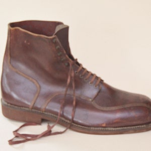 May include: A brown leather lace-up boot with a rounded toe and a thick sole.