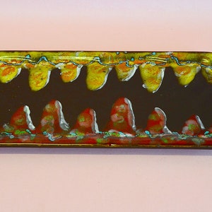 May include: A rectangular ceramic serving tray with a brown base and a colourful glaze design. The glaze features yellow, orange, red, and blue accents in a wavy pattern.