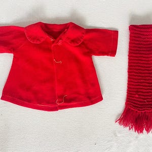 May include: A red corduroy jacket with a collar and a matching red knitted scarf.