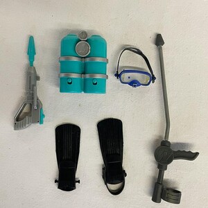 May include: A set of scuba diving accessories including a teal scuba tank, black flippers, a grey spear gun, a grey snorkel, and a blue diving mask.