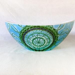 Op de afbeelding: Een grote, ovale serveerschaal met een blauw en groen mandala-ontwerp. De schaal is gemaakt van keramiek en heeft een glanzende afwerking.