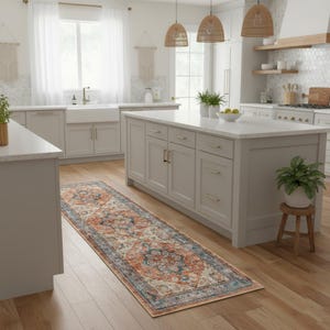 Peut inclure: Un tapis de couloir rectangulaire avec un motif complexe d'inspiration vintage dans des tons d'orange, de bleu et de cr&egrave;me. Le tapis est pos&eacute; sur un sol en bois dans une cuisine, ajoutant une touche de chaleur et de motif &agrave; l'espace.